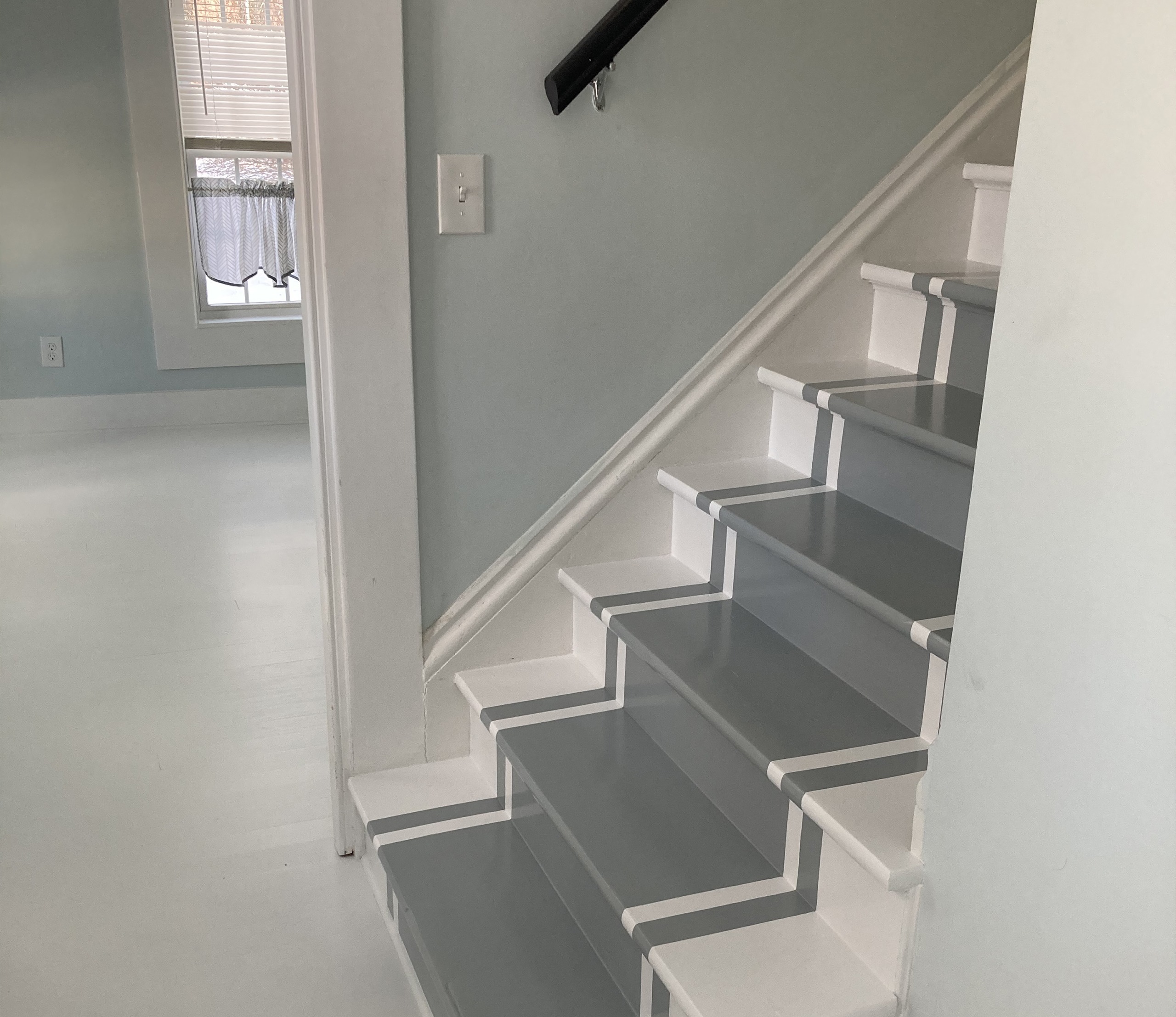 A stairway featuring a mix of white and gray paint